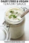 tzatziki in a glass jar with dill and a spoon inside