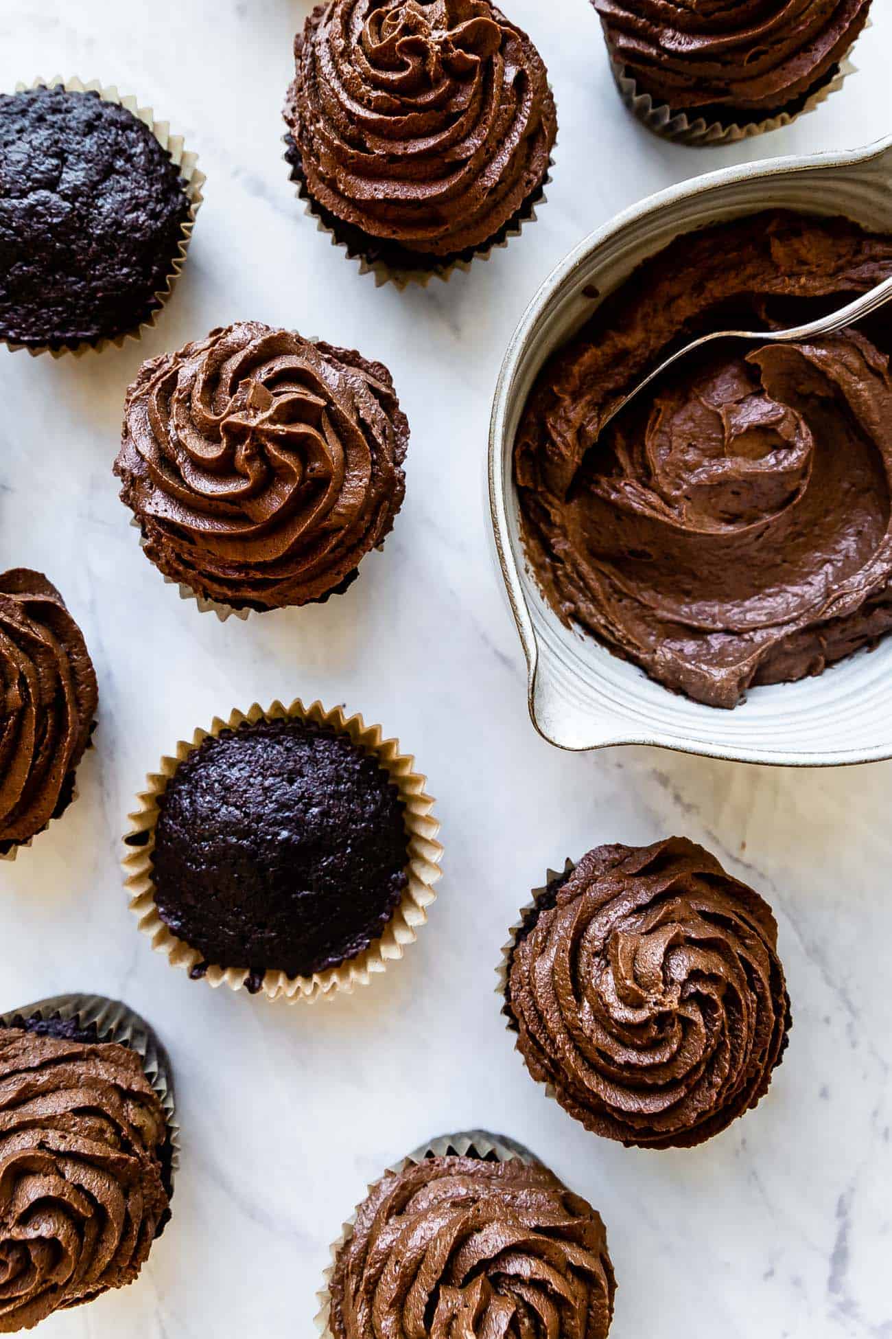 chocolate cupcakes with chocolate buttercream on a marble board