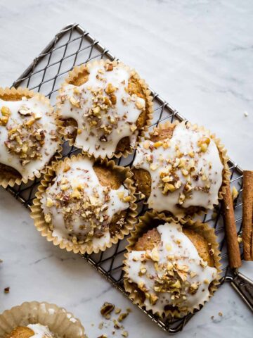 carrot cake muffins with glaze and nuts on a wire rack
