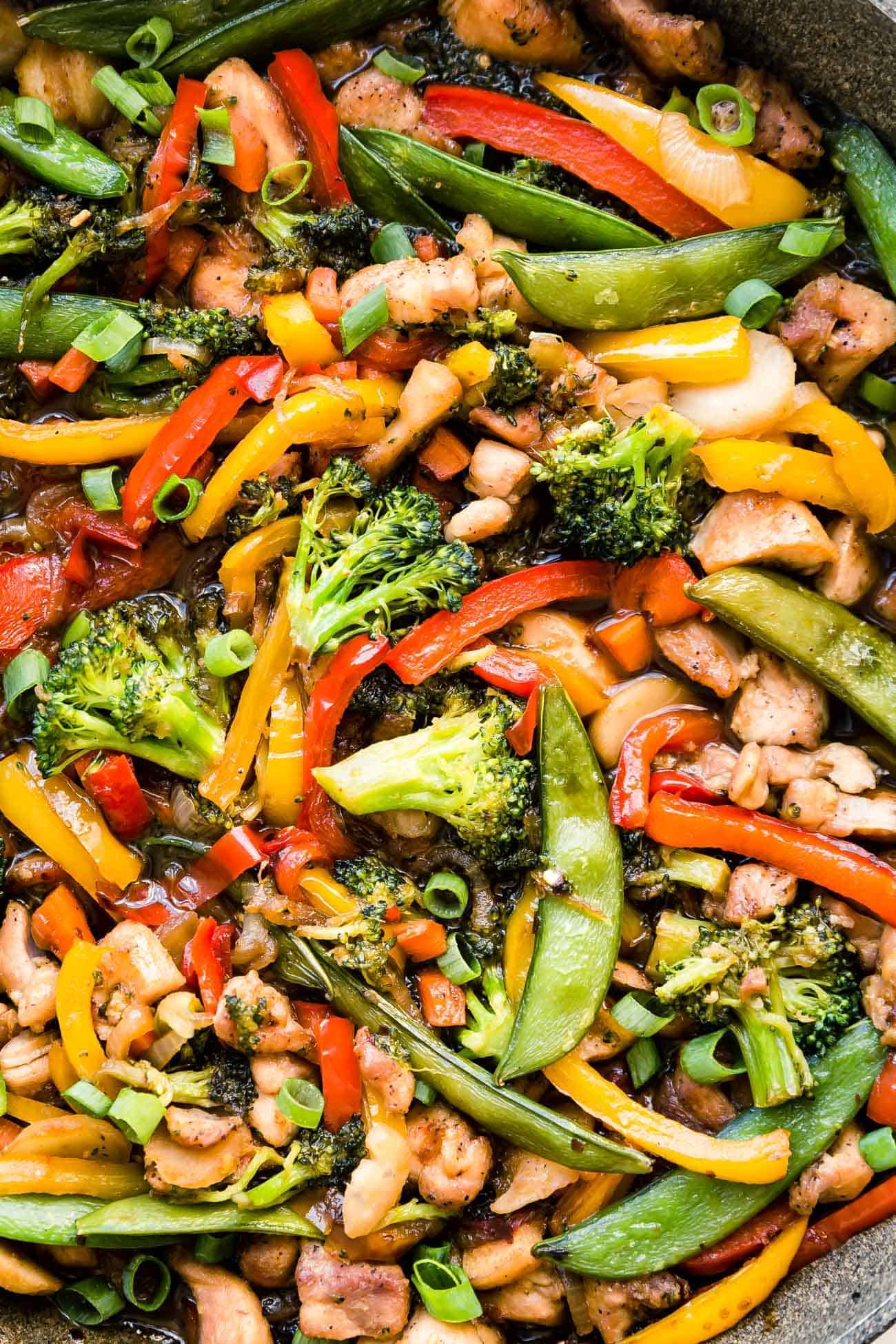 close of chicken stir fry with broccoli, bell peppers, snap peas and carrots