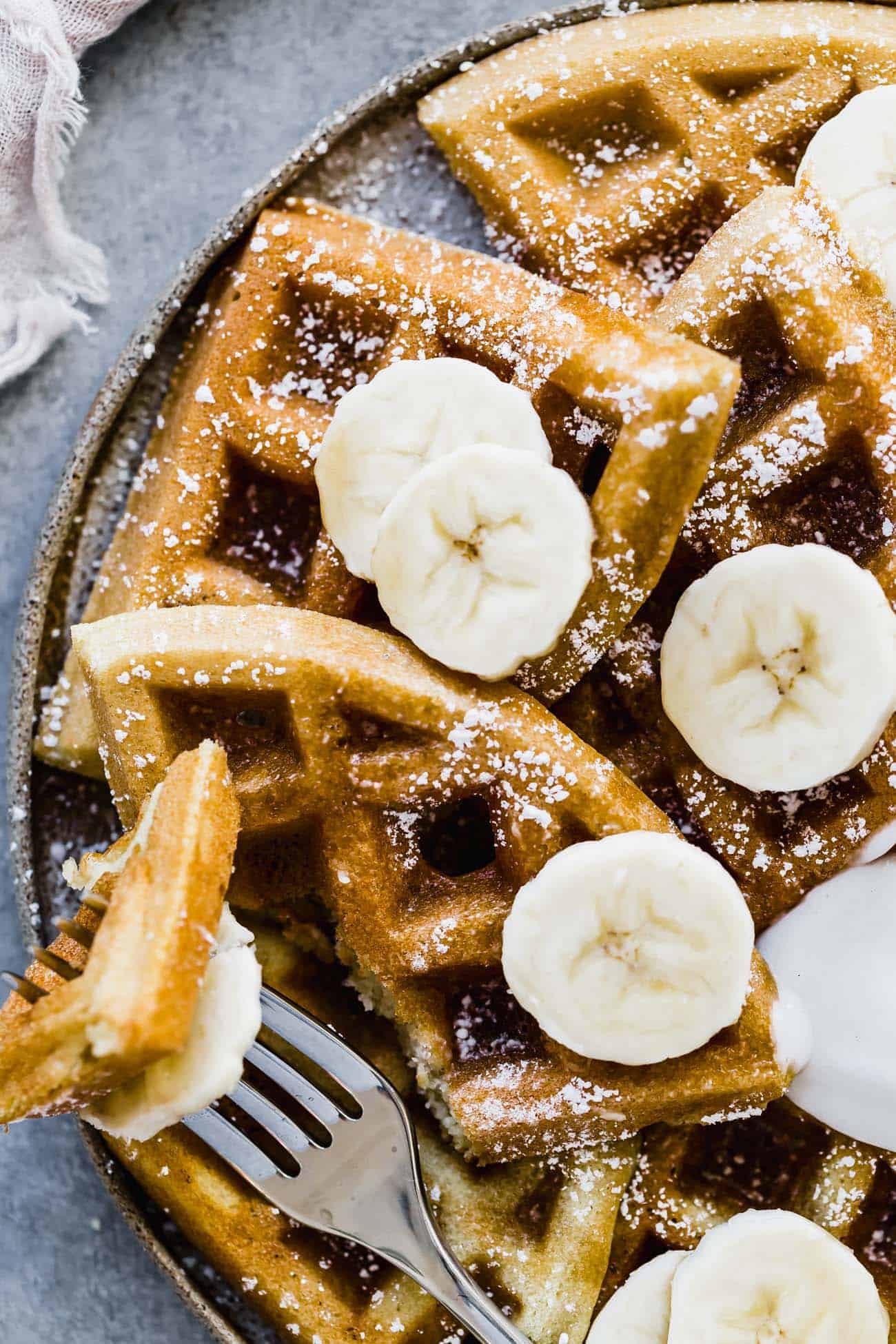bite of protein waffles on a fork with sliced bananas