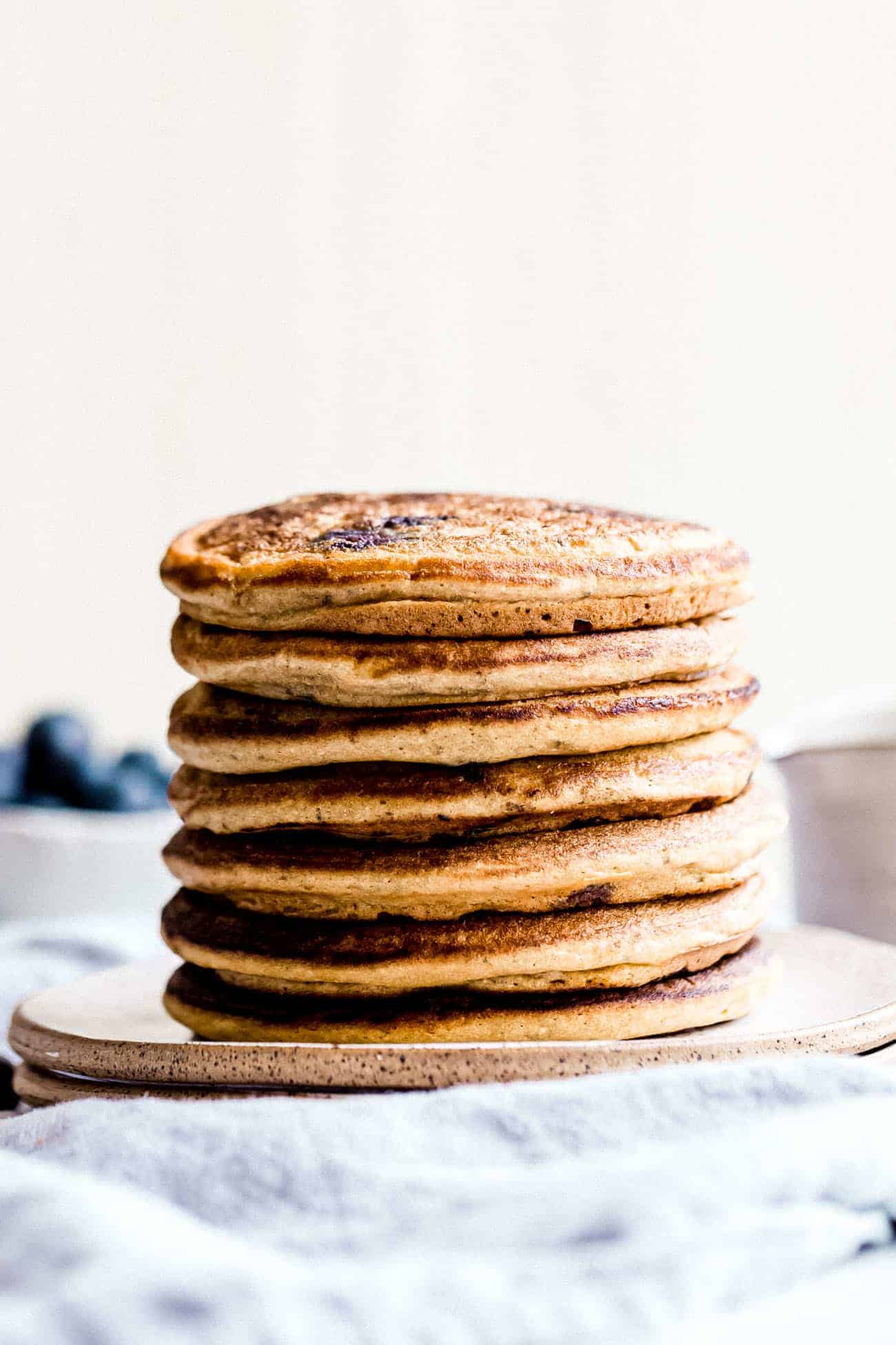 tall stack of paleo blueberry pancakes on a ceramic plate