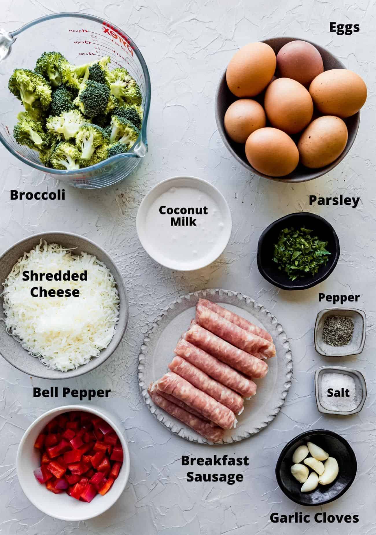 ingredients to make a low carb egg bake: Eggs, Brccoli, Coconut Milk, Parsley, Shredded Cheese, Bell Pepper, Breakfast Sausage, Pepper, Salt, Garlic Cloves