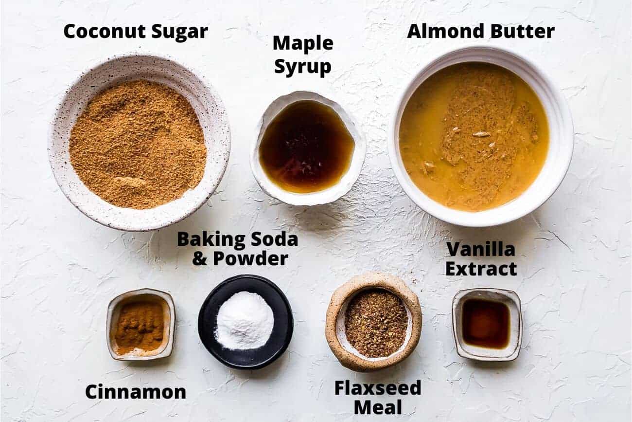 ingredients for vegan almond butter cookies: Coconut sugar, maple syrup, almond butter, baking soda & powder, cinnamon, flax seed, vanilla extract