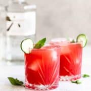 watermelon gin cocktails with a bottle of gin in the background