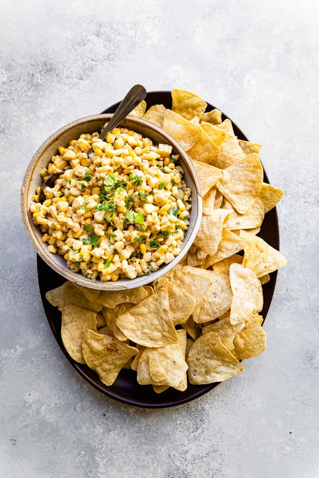 elote dip on a platter with corn chips