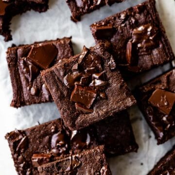 dark chocolate pumpkin brownies stacked together on parchment paper