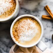 vegan pumpkin spice lattes in mugs with cinnamon and foam