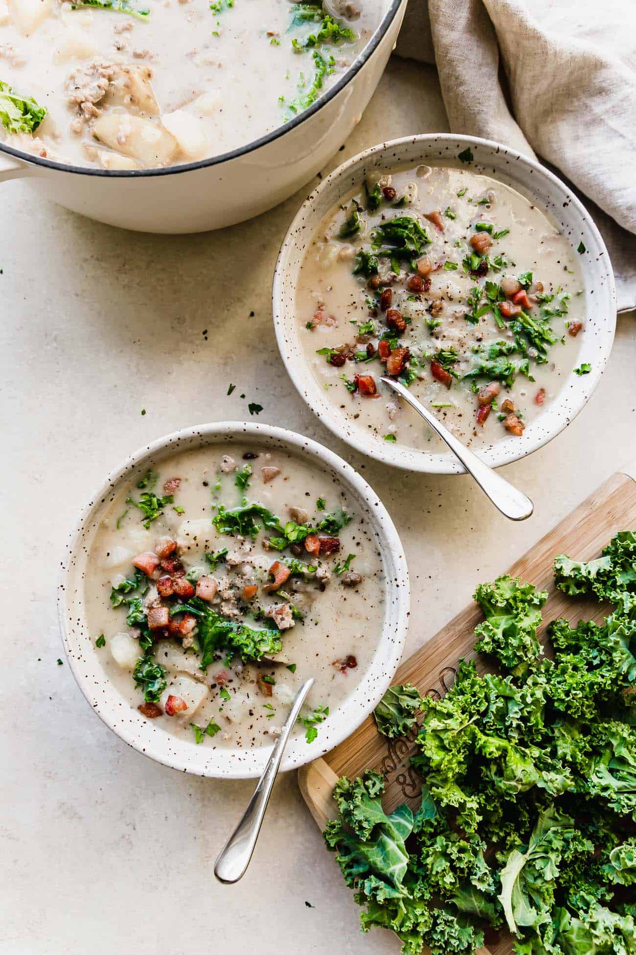 two bowls of Zuppa Toscana with kale on the side