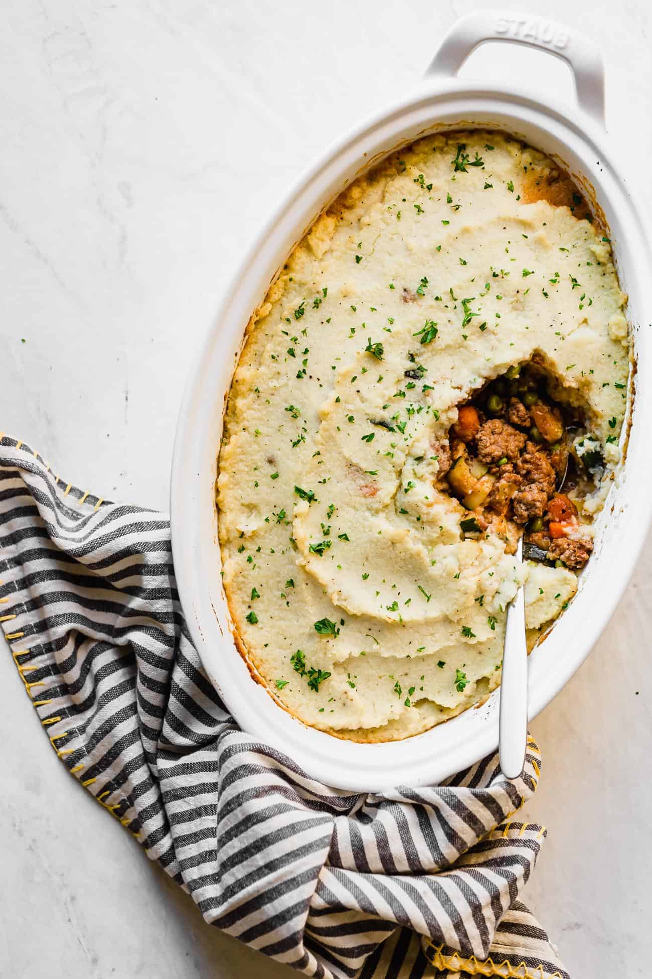 keto shepherd's pie in a white pan with a spoon inside