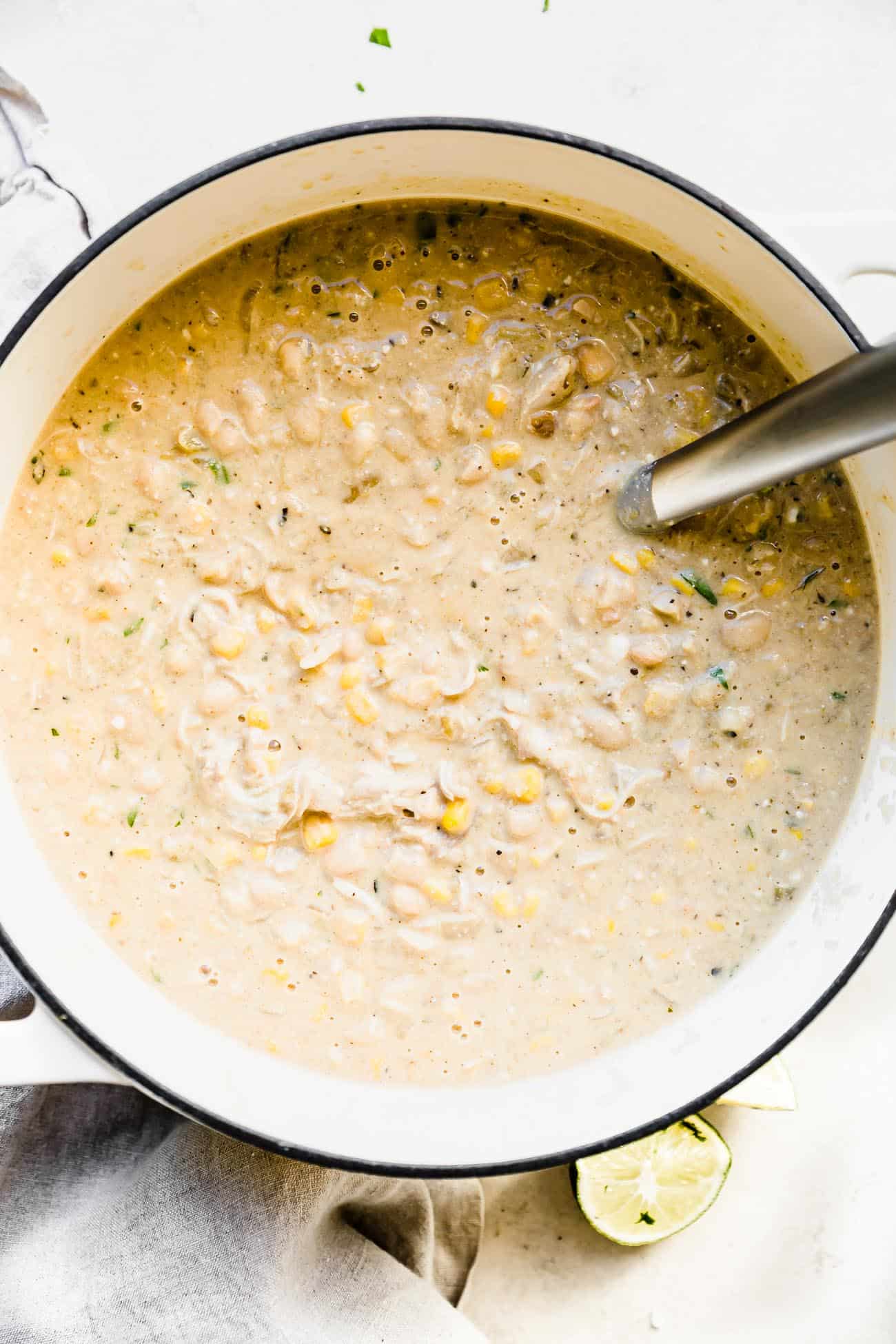 white chicken chili in a white soup pot with a ladle inside
