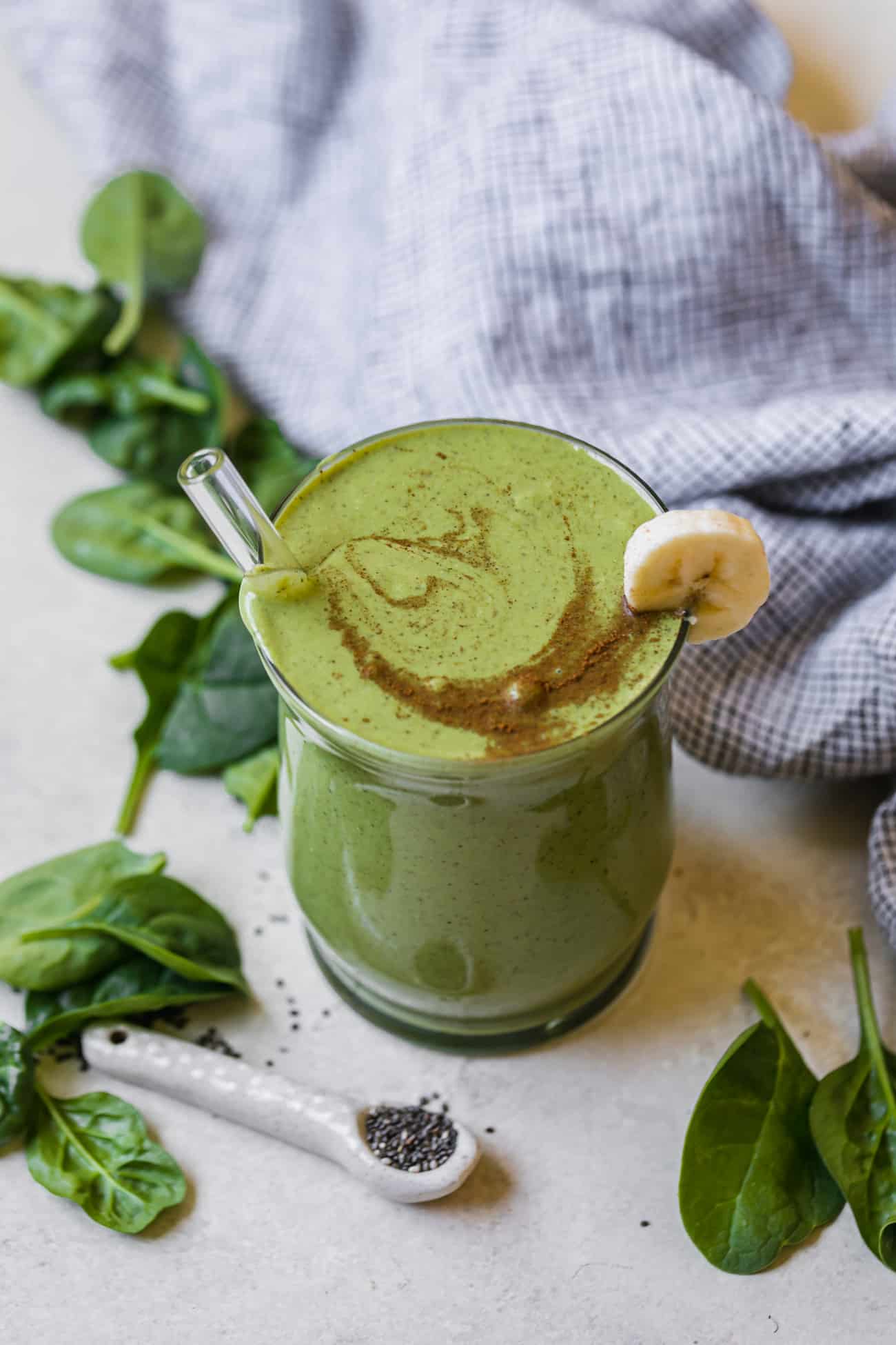 banana spinach smoothie with spinach leaves and linen napkin