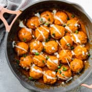 buffalo chicken meatballs in a pan with green onions