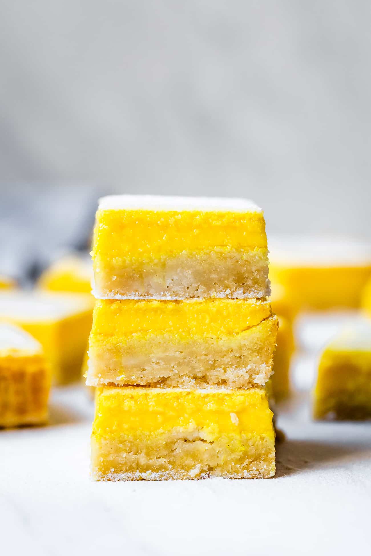 stack of gluten free and keto lemon bars on a marble board