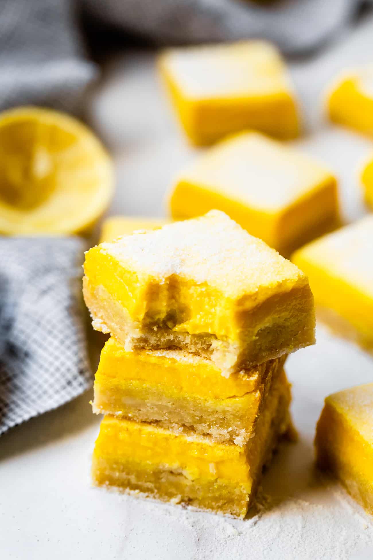 stack of lemon bars with a bite taken out at the top