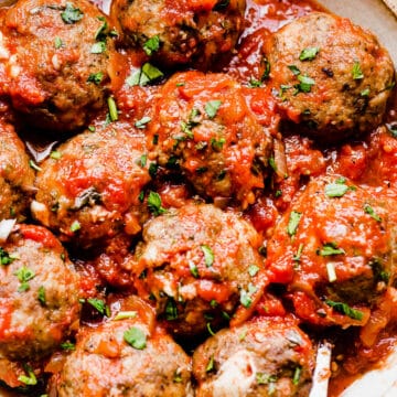 mozzarella stuffed meatballs with tomato sauce in a bowl with a spoon
