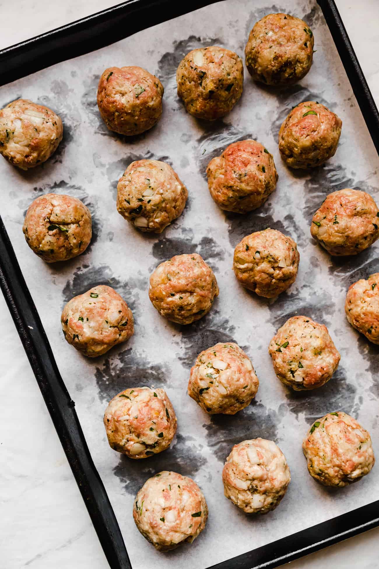 meatballs prepped on a parchment lined baking sheet