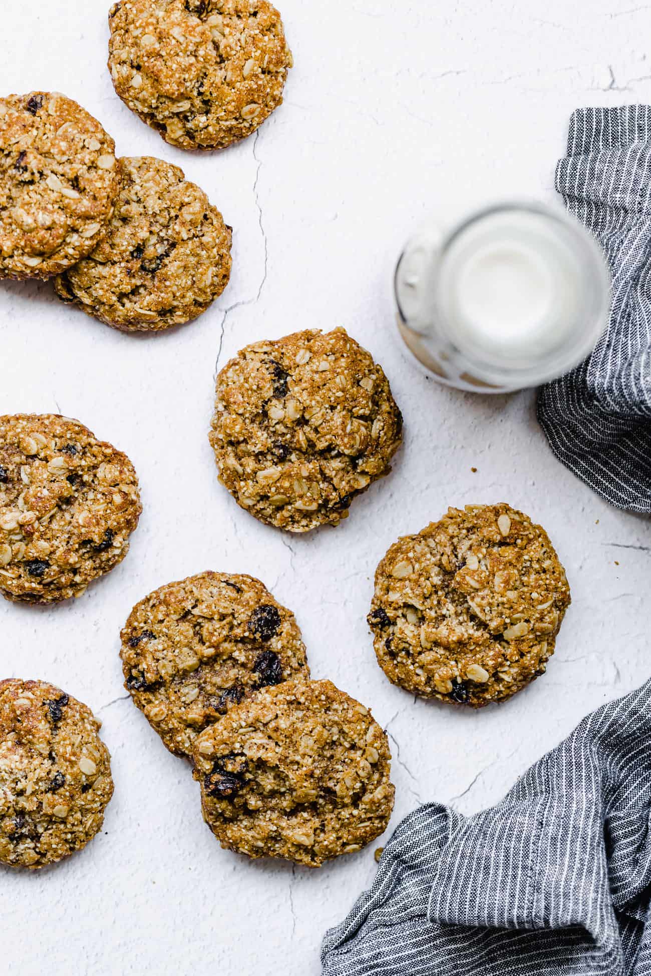 healthy oatmeal raisin cookies laid out with a jug of milk on the side