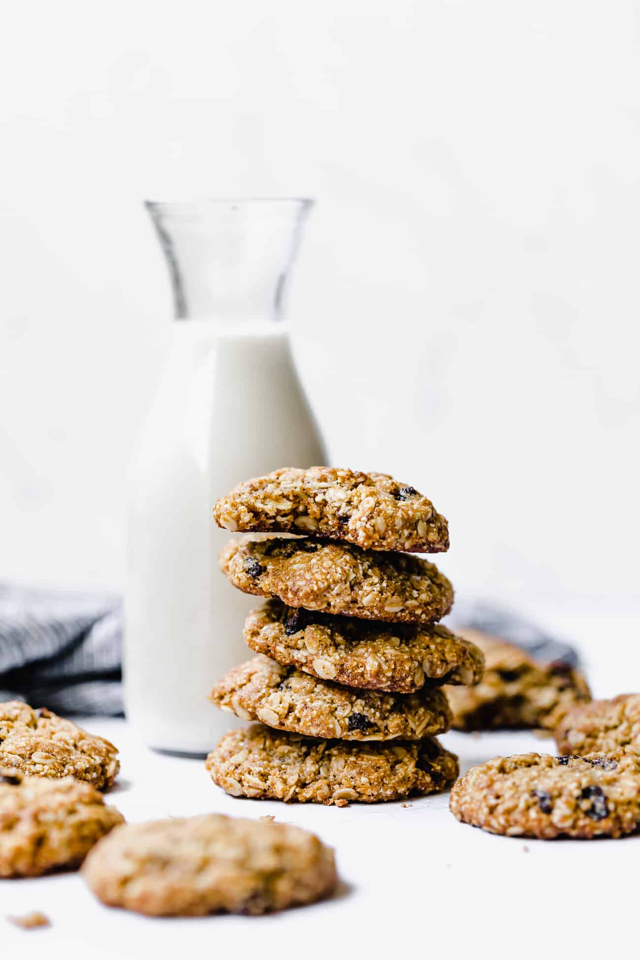 stack of healthy oatmeal raisin cookies against a jug of milk