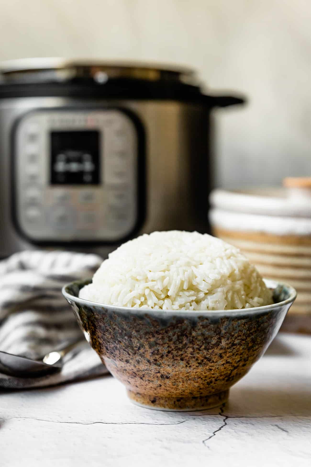 jasmine rice in a bowl with instant pot behind it