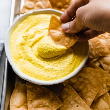 corn chips being dipped into cheese dip