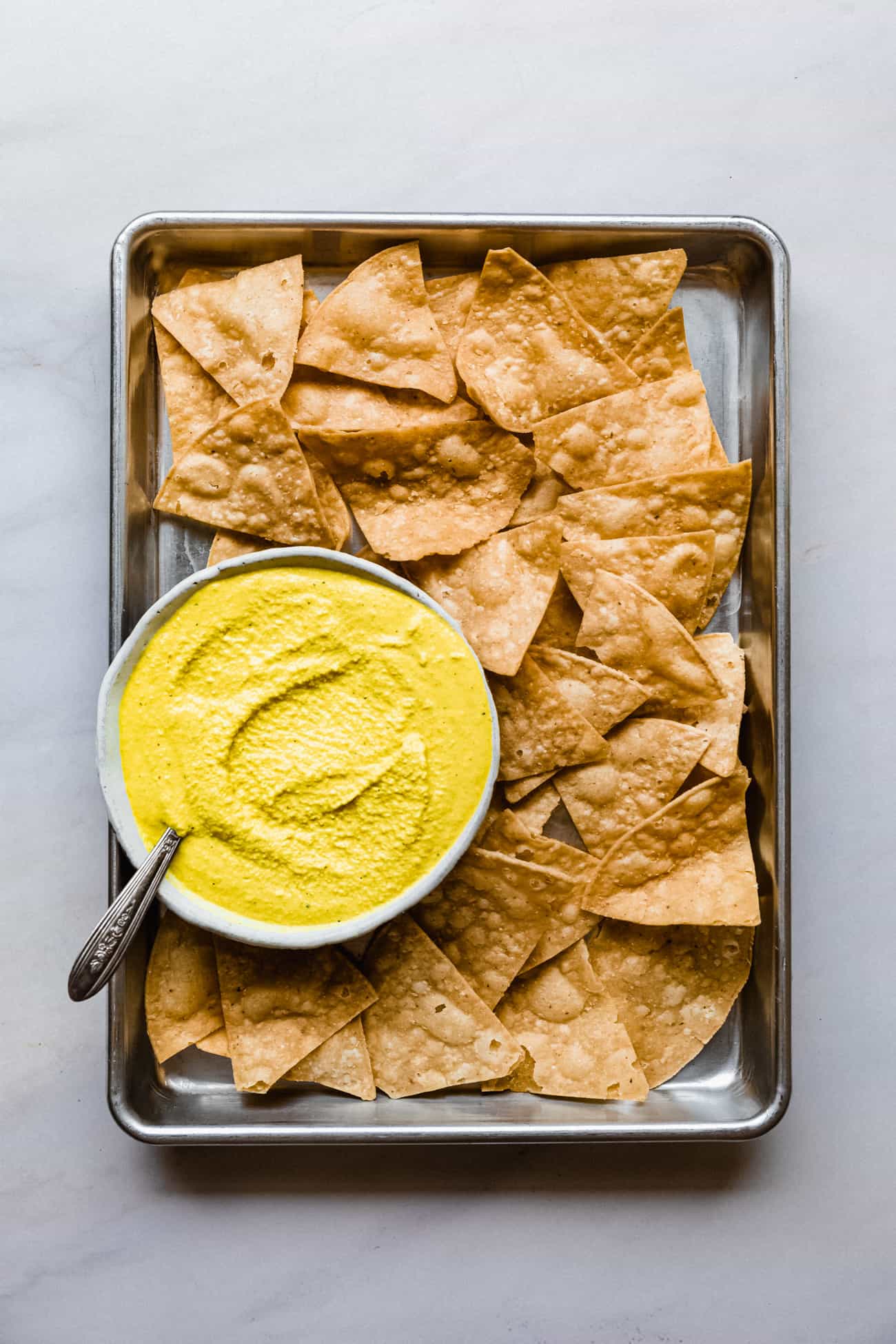 a tray full of corn chips with nacho cheese dip