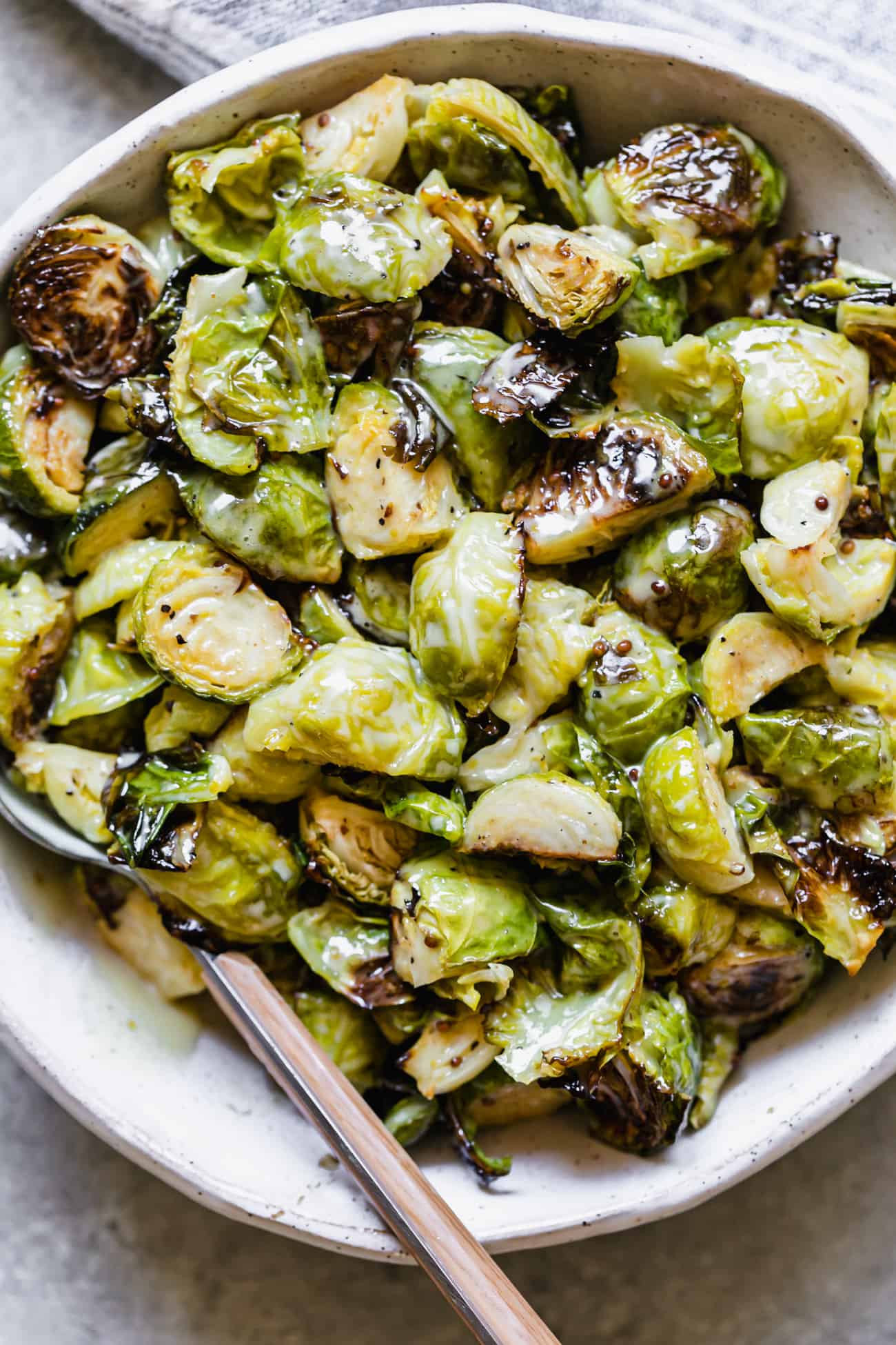 creamy honey mustard brussels sprouts in a white bowl