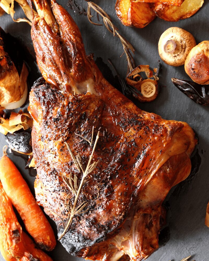 slow roasted leg of lamb on cutting board