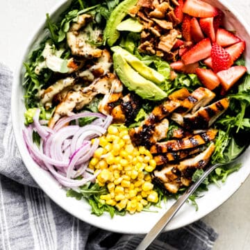 honey mustard chicken salad with avocado, onions, and corn in a large bowl
