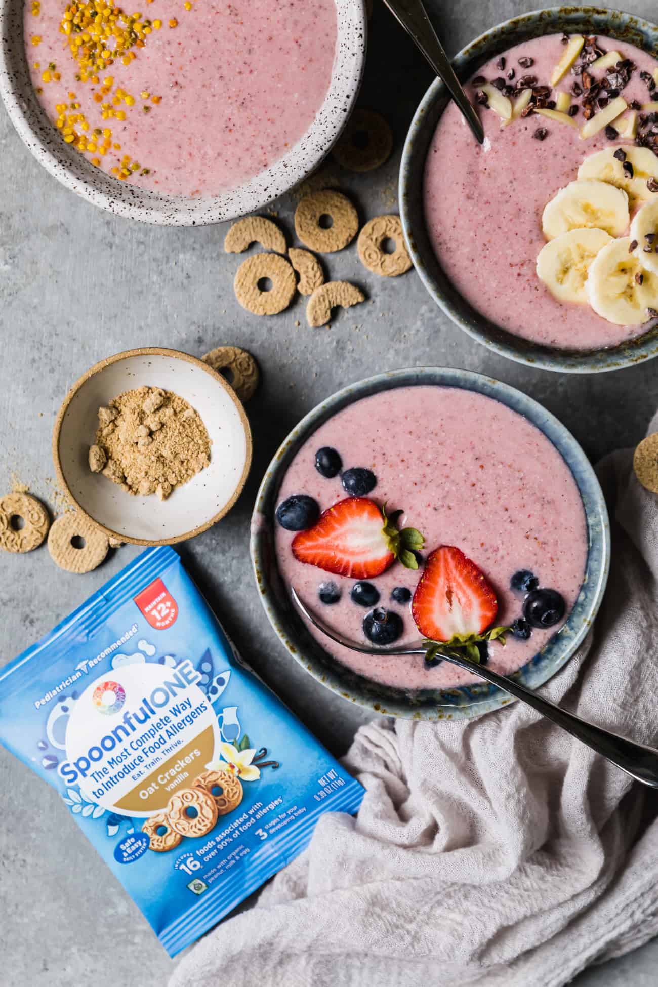 pink smoothie bowls with a bag of spoonful one crackers next to it