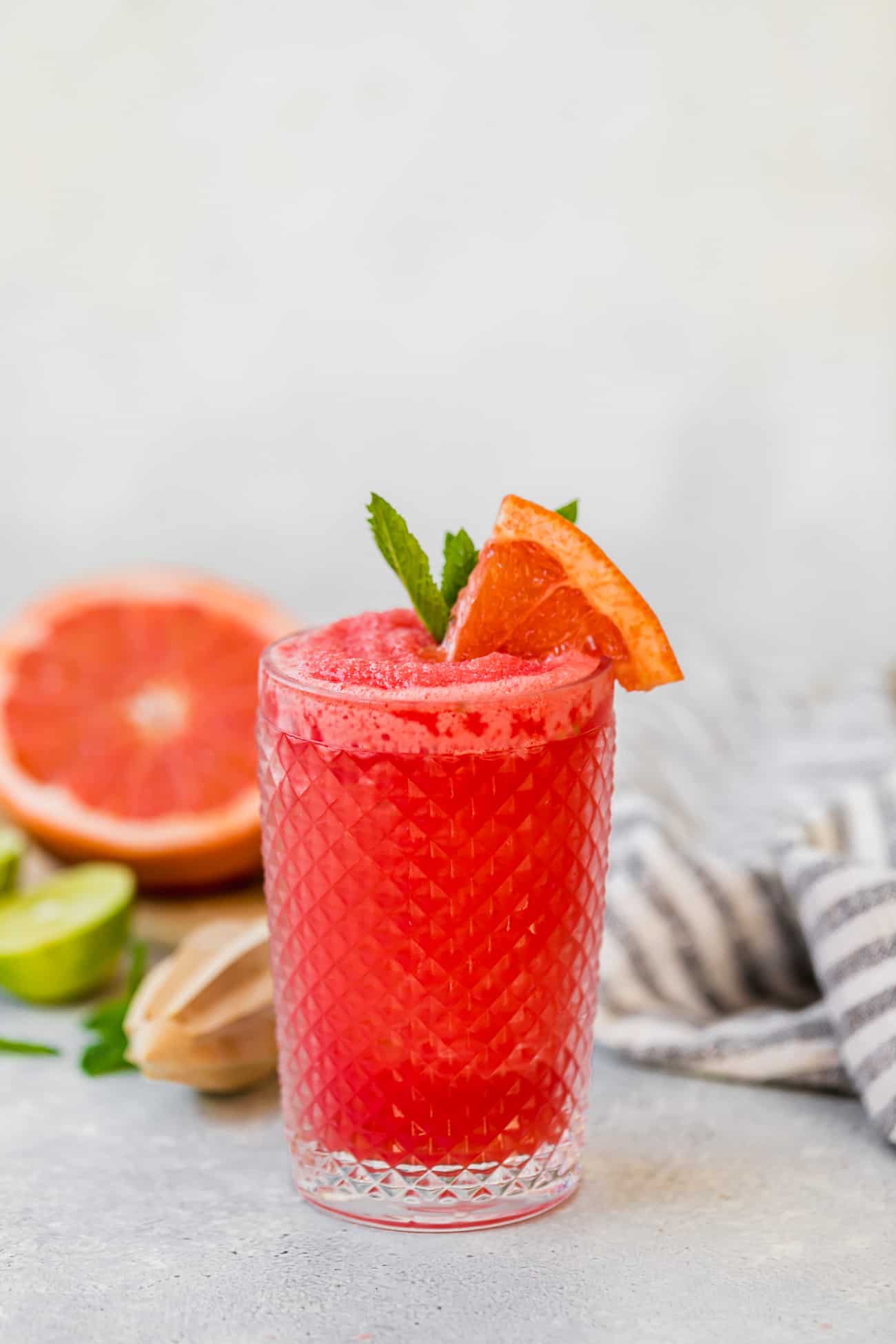 watermelon paloma in a glass with mint and fresh grapefruit garnish