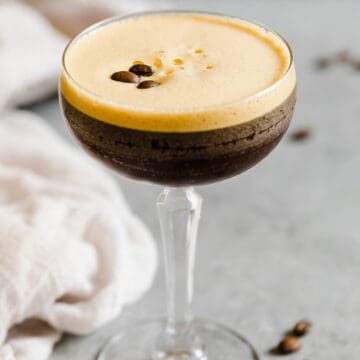 espresso martini in a glass with foam and espresso beans on top