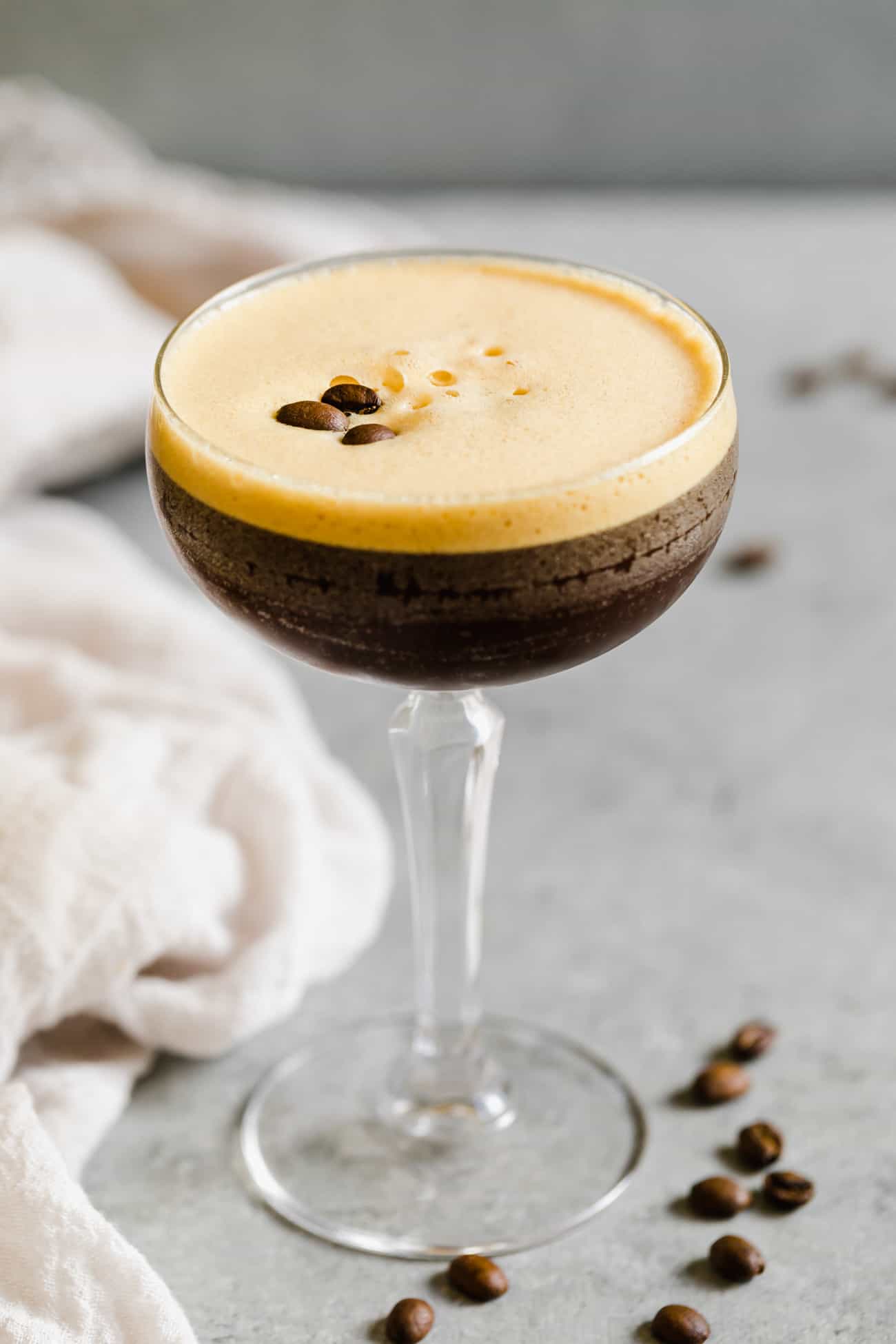 espresso martini in a glass with foam and espresso beans on top