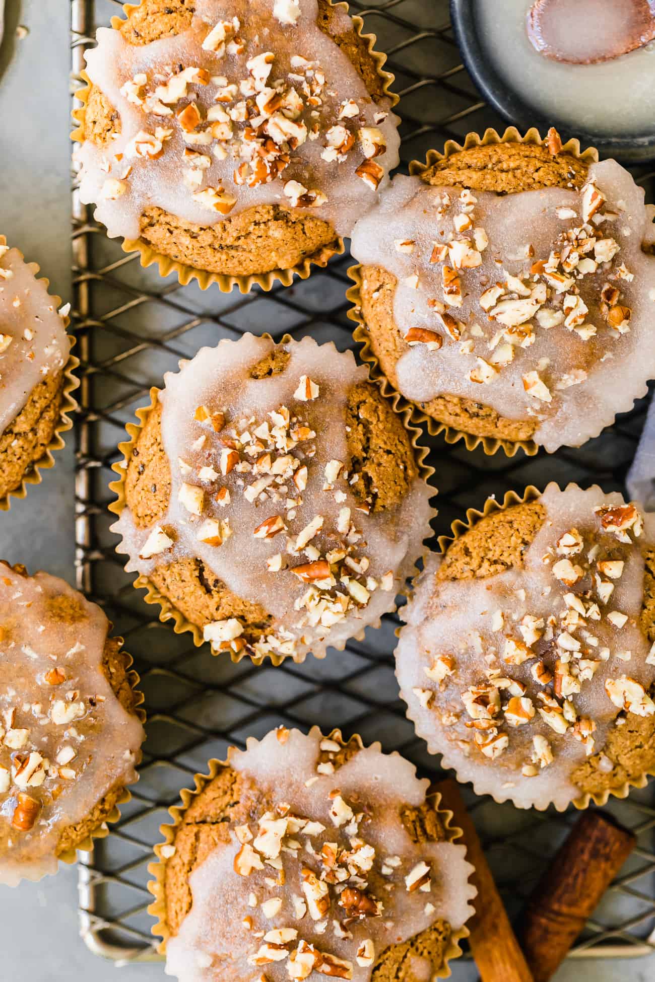 cinnamon muffins topped off with a white glaze and chopped pecans