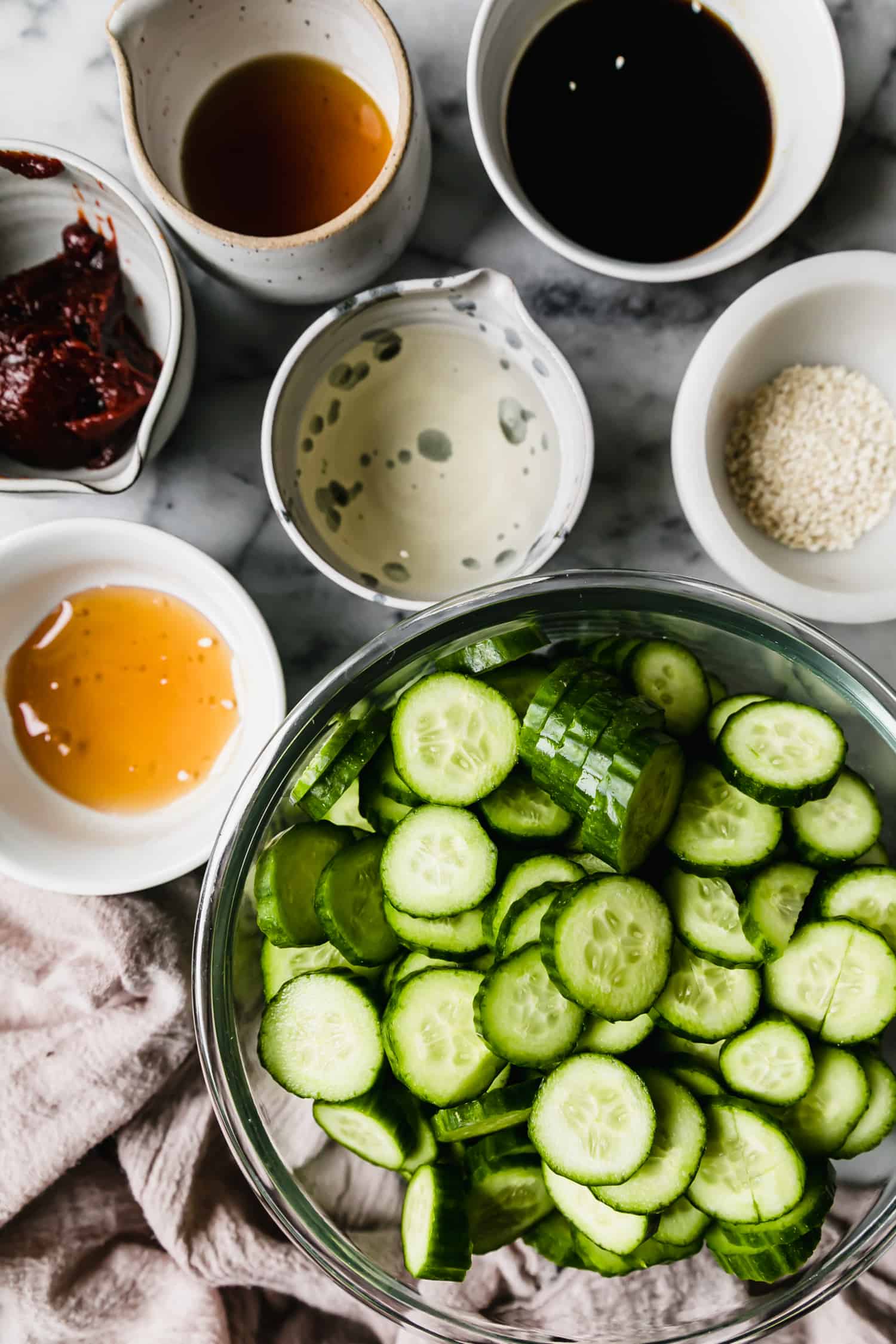 ingredients prepped in bowls to make cucumber salad